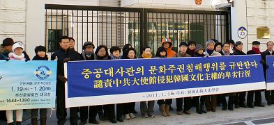 二零一一年一月十六日上午十一点，韩国釜山各界民众冒着寒冷天气，抗议中共驻韩大使馆干扰美国神韵艺术团来韩演出的行径。