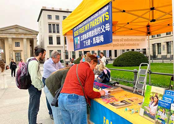 Image for article Berlin, Germany: Tourists Hold Up a Falun Dafa Banner to Show Their Support